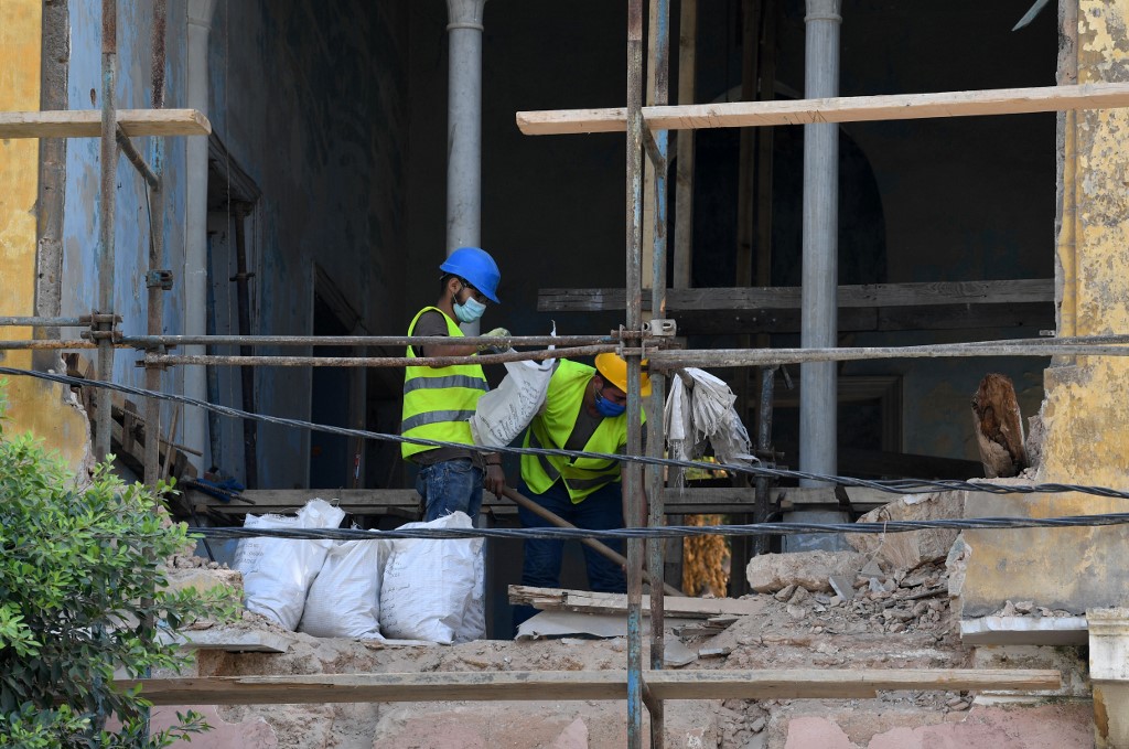 Des bénévoles chargés de la reconstruction des bâtisses endommagées (Joseph Eid/AFP)