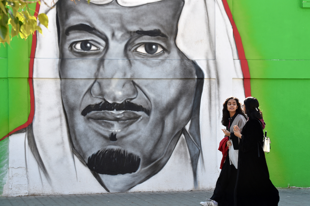 Des Saoudiennes passent devant une peinture murale représentant le roi Salmane dans la rue Tahliya à Riyad, la capitale. (AFP/Fichier Photo)