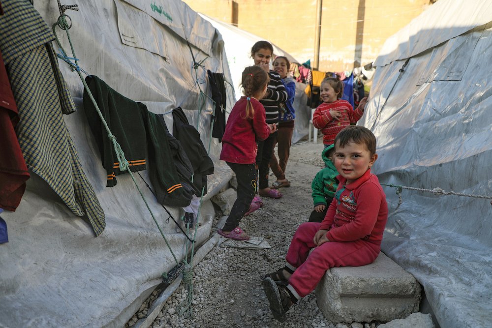 Des enfants syriens déplacés par la guerre se rassemblent dans un camp de fortune au stade de football d'Idlib le 3 mars 2020 dans la ville d'Idlib, dans le nord-ouest de la Syrie. (AFP / Fichier Photo)