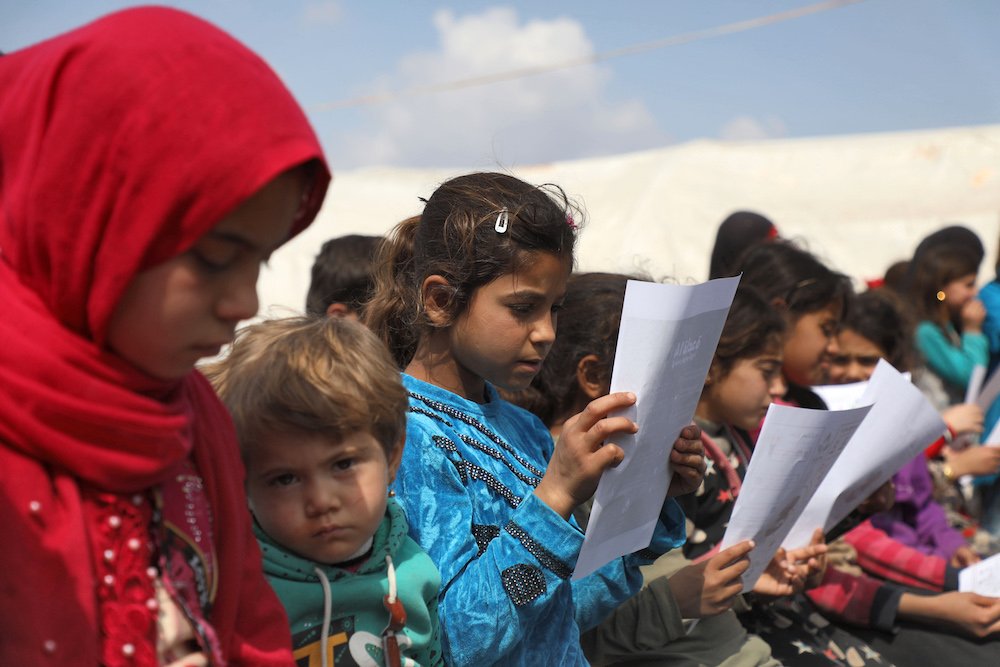 Des enfants syriens déplacés assistent à un atelier visant à sensibiliser à la maladie du coronavirus et aux précautions à prendre pour sa prévention, dans un camp 9-+près de la ville syrienne d'Atme près de la frontière avec la Turquie à Idlib le 16 mars 2020 (AFP / Fichier Photo)