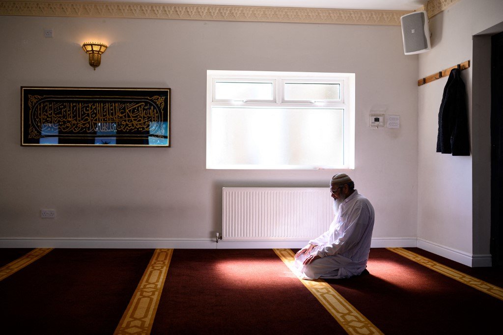 Un membre du personnel de la mosquée prie dans la mosquée Noor Ul Islam, vide, la veille du début du Ramadan au Royaume-Uni, à Bury, dans le Grand Manchester, le 24 avril 2020 (AFP)