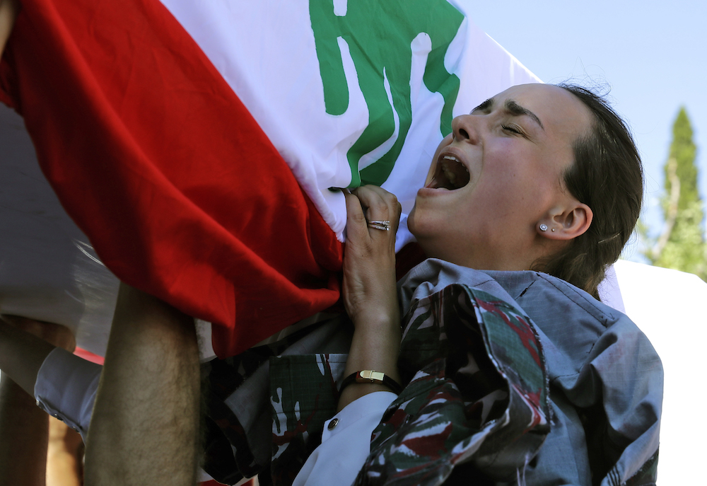 Karlen pleure devant le cortège funèbre de son mari Charbel Karam, de son frère Najib Hitti et de son cousin Charbel Hitti, dans leur ville natale de Qartaba, au nord de la capitale libanaise Beyrouth, le 17 août 2020. (AFP)