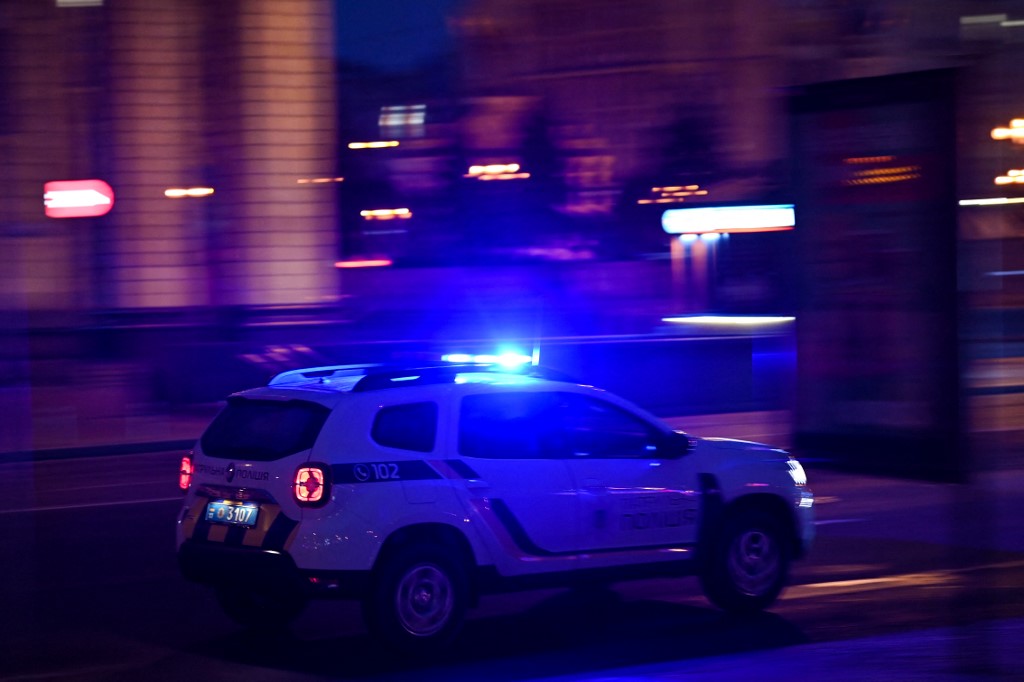 Une voiture de police roule dans une rue du centre de Kiev tôt le 24 février 2022. (Photo, AFP)