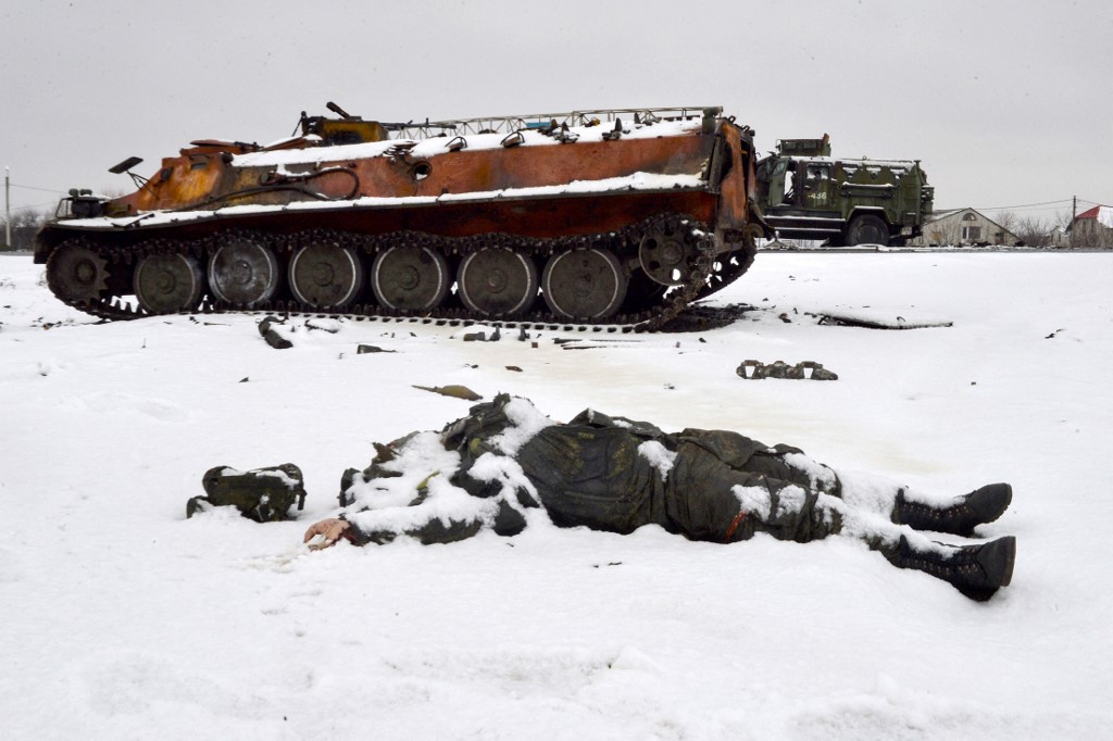 Le corps d'un militaire russe près de véhicules militaires russes détruits sur le bord de la route à la périphérie de Kharkiv, le 26 février 2022, à la suite de l'invasion russe de l'Ukraine. (Photo, AFP)