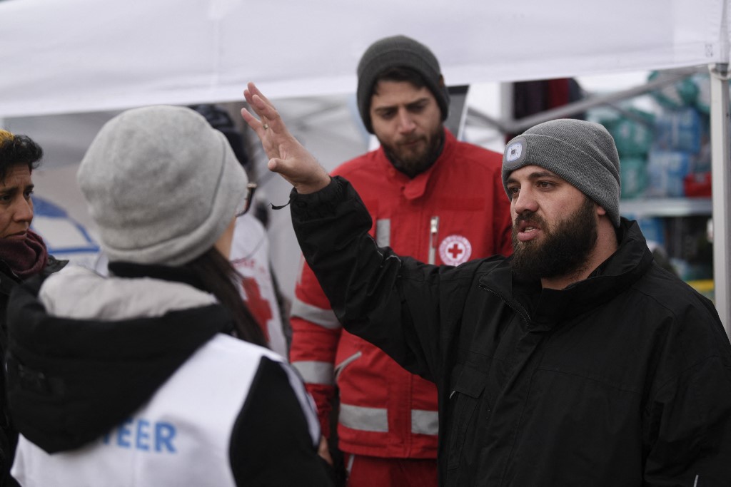 Le Syrien Omar Alshakal parle à des volontaires de la Croix-Rouge à la frontière ukraino-roumaine près de la ville de Siret, en Roumanie, le 16 mars 2022.