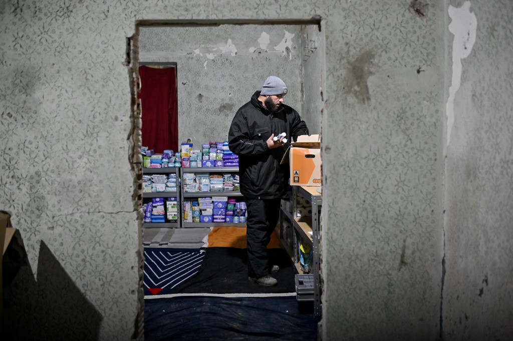 Le Syrien Omar Alshakal range des paquets de dons dans un entrepôt près de la ville de Siret, en Roumanie, le 16 mars 2022. 