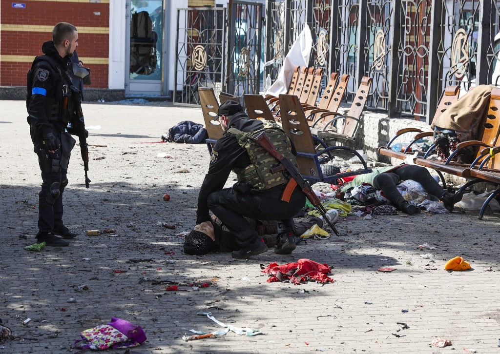 Des militaires ukrainiens passent parmi les blessés allongés sur la plate-forme à la suite d'une attaque à la roquette contre la gare de la ville orientale de Kramatorsk, dans la région du Donbass, le 8 avril 2022 (Photo, AFP). 