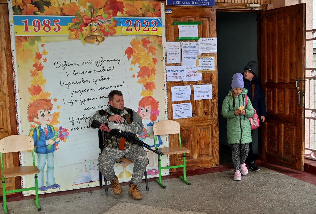 Un militaire ukrainien de la défense territoriale garde à l'entrée d'une école le 21 avril 2022 dans la petite ville ukrainienne de Borodyanka, dans la région de Kiev (Photo, AFP).
