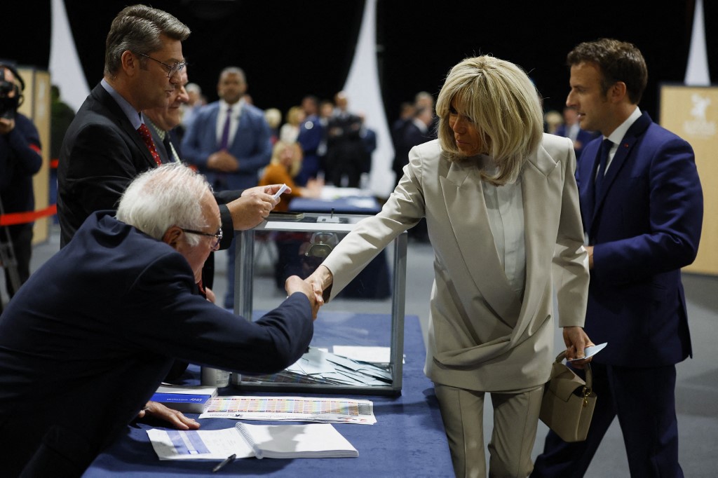 Le président français Emmanuel Macron et son épouse Brigitte Macron saluent les officiels alors qu'ils arrivent pour voter (Photo, AFP).