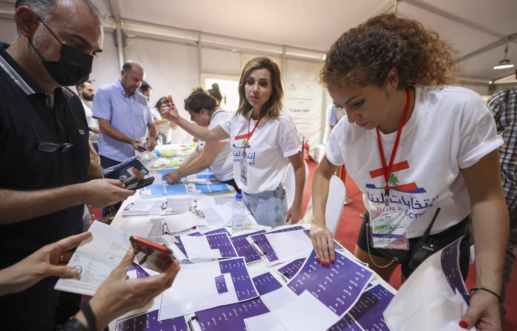 Les expatriés libanais vérifient les listes avec le personnel électoral avant de voter pour les élections législatives du 15 mai au consulat du Liban dans l'émirat du Golfe de Dubaï le 8 mai 2022 (Photo, AFP).