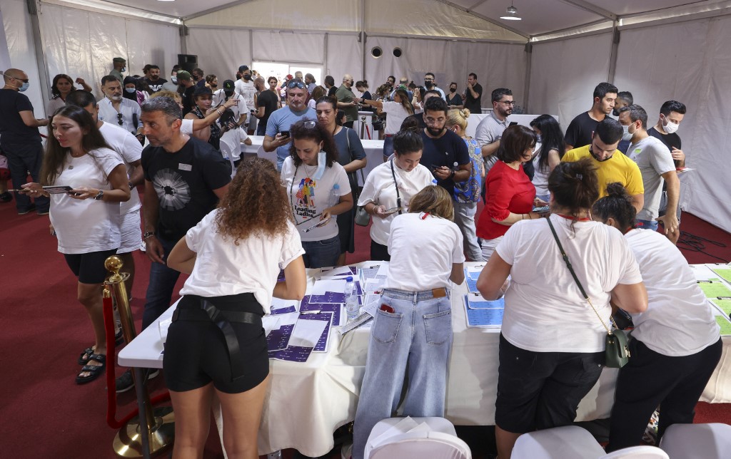 Les expatriés libanais vérifient les listes avec le personnel électoral avant de voter pour les élections législatives du 15 mai au consulat du Liban dans l'émirat du Golfe de Dubaï le 8 mai 2022 (Photo, AFP).