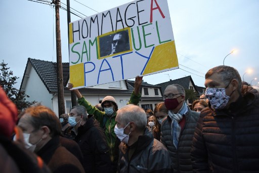 Un homme tient une pancarte indiquant « Hommage à Samuel Paty » lors de la « Marche Blanche » le 20 octobre 2020, à Conflans-Sainte-Honorine (Photo, AFP)