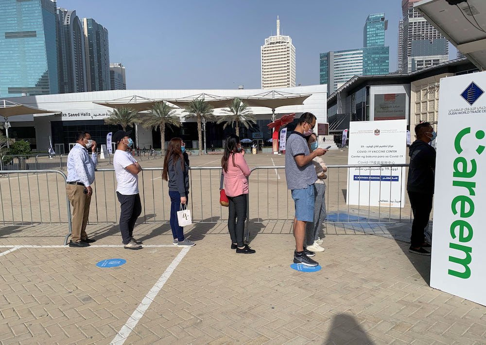 Les gens font la queue devant un centre de vaccination contre la COVID-19 situé dans le centre financier de Dubaï. (AFP/File Photo)