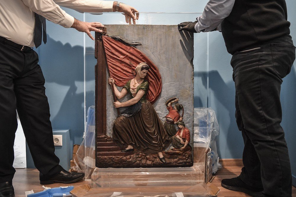 Les employés du musée déballent une œuvre représentant l'héroïne de la révolution grecque, Laskarina Bouboulina, dans le nouveau musée dédié aux volontaires étrangers philhellènes qui ont combattu et sont morts pour la Grèce le 12 mars 2021 (AFP / File Photo)