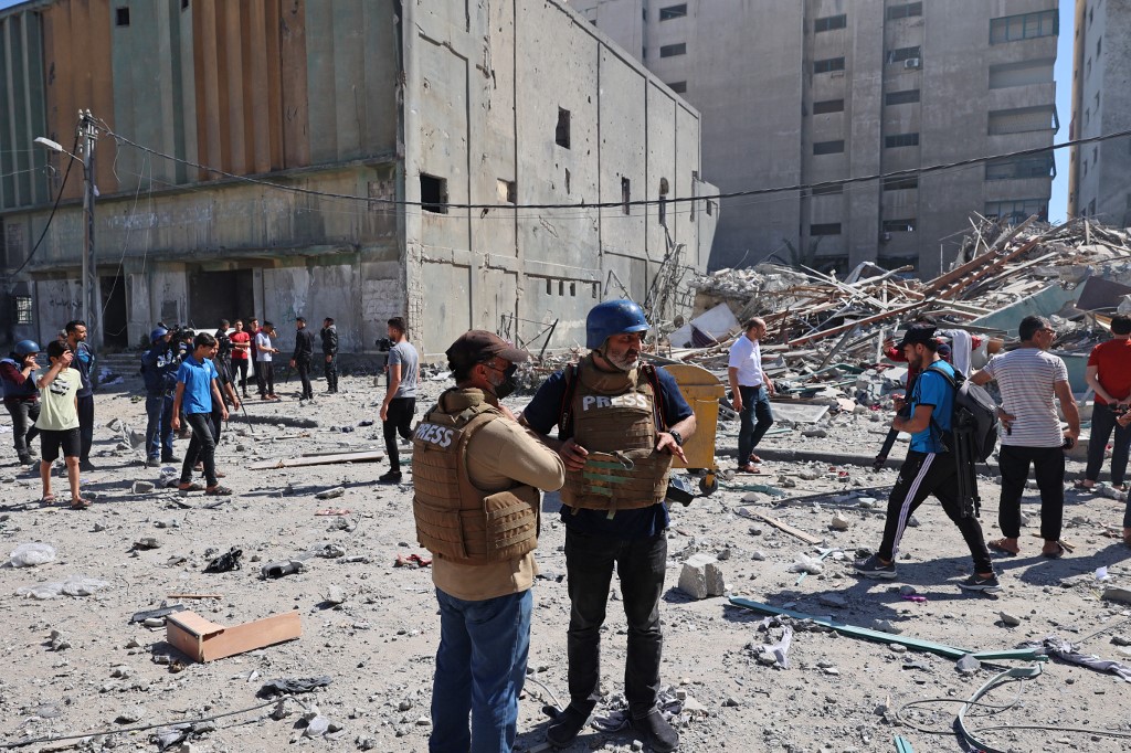 Des journalistes de l'Associated Press sont sous le choc à côté des décombres de la tour Jala, qui abritait des bureaux de presse internationaux, à la suite d'une frappe aérienne israélienne dans la bande de Gaza le 15 mai 2021