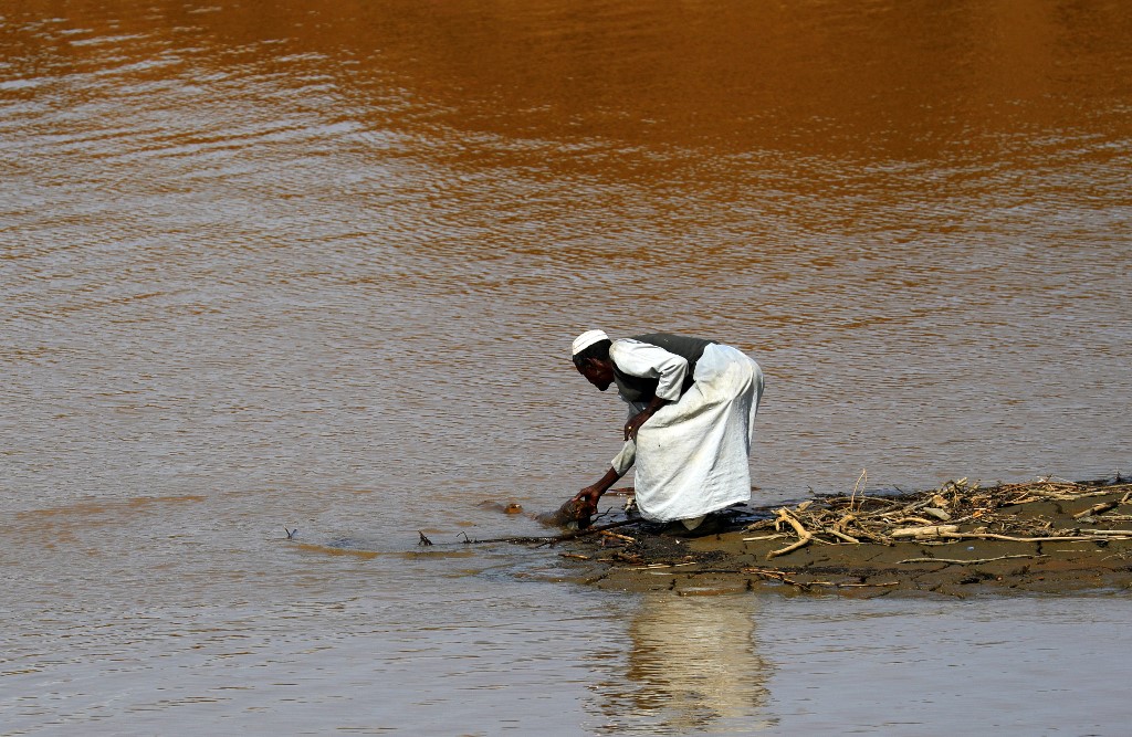Un réfugié tigréen se tient sur les rives de la rivière Setit à la frontière de l'Éthiopie, à Wad al-Hiliou, un village de l'État soudanais oriental de Kassala, le 11 août 2021.
