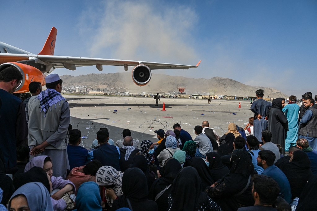 Les passagers afghans sont assis en attendant de quitter l'aéroport de Kaboul à Kaboul le 16 août 2021. (Photo, AFP)