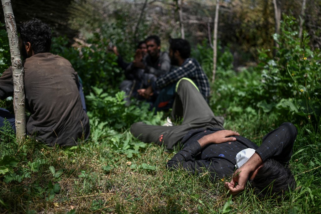 Un migrant afghan se repose en attendant d'être transporté par des passeurs après avoir traversé la frontière irano-turque le 15 août 2021 à Tatvan, sur la rive ouest du lac de Van, dans l'est de la Turquie