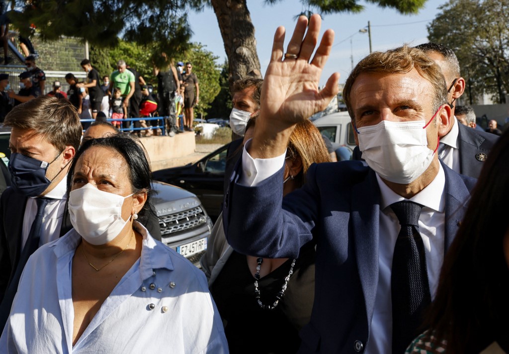 Le président français Emmanuel Macron salue les habitants du quartier de Bassens à côté du maire de Marseille Benoit Payan (L) le premier jour d'une visite de trois jours à Marseille, dans le sud de la France, le 1er septembre 2021