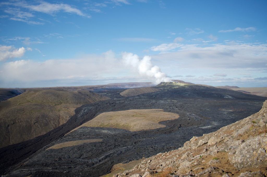 Le panache du cratère actif dans la vallée de Geldingadalir et une partie du champ de lave de 4,63 km2 sont vus depuis une montagne près du site de l'éruption le 15 septembre 2021 à Fagradalsfjall, dans le sud-ouest de l'Islande.