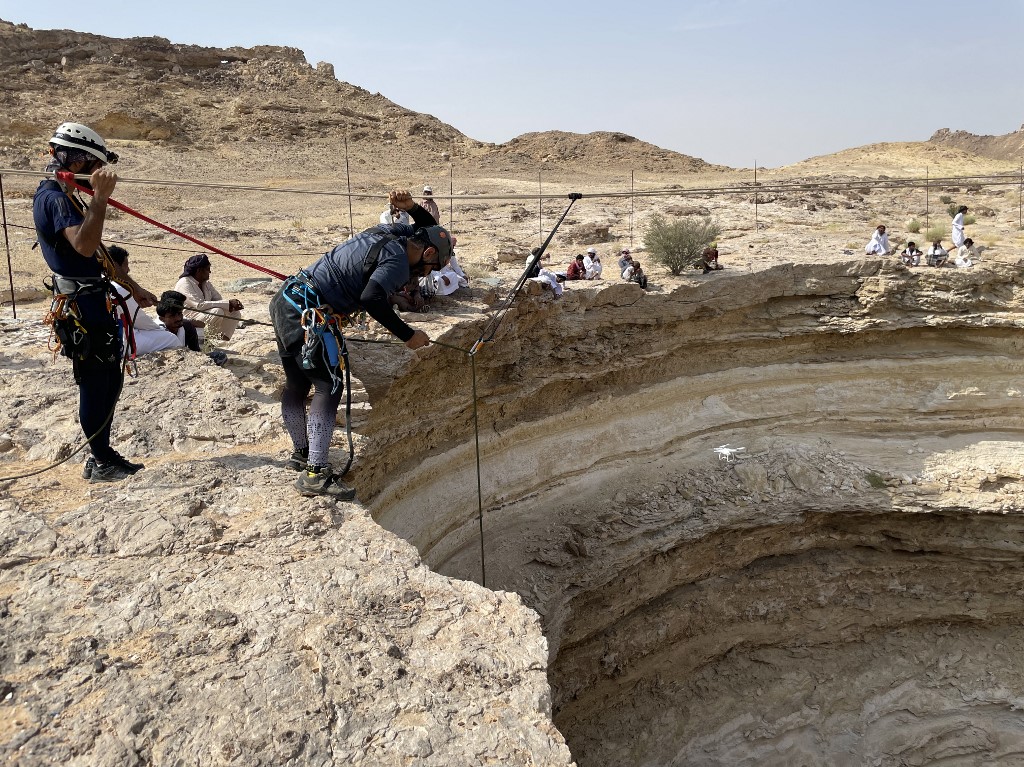 Une photo prise par l'équipe d'exploration de grottes d'Oman le 15 septembre 2021, montre les spéléologues de l'équipe se préparant à descendre en rappel le puits de Barhout, un gouffre connu sous le nom de "puits de l'enfer" dans le désert de la province d'Al-Mahra au Yémen