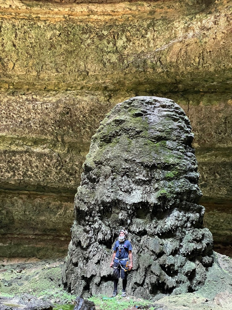 Une photo prise par l'équipe d'exploration de grottes d'Oman le 15 septembre 2021, montre l'un des spéléologues de l'équipe debout près d'une stalagmite au fond du puits de Barhout, un gouffre connu sous le nom de "puits de l'enfer" dans le désert d'Al au Yémen -Province de Mahra