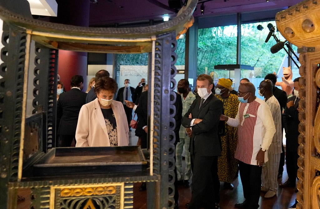 Le président français Emmanuel Macron (au centre) et la ministre française de la Culture Roselyne Bachelot (à gauche) regardent un trône royal du Bénin du XIXe siècle exposé au musée du quai Branly avant d'être expédié vers le pays d'Afrique de l'Ouest plus tard ce mois-ci, à Paris le 27 octobre 2021. (Photo, AFP)