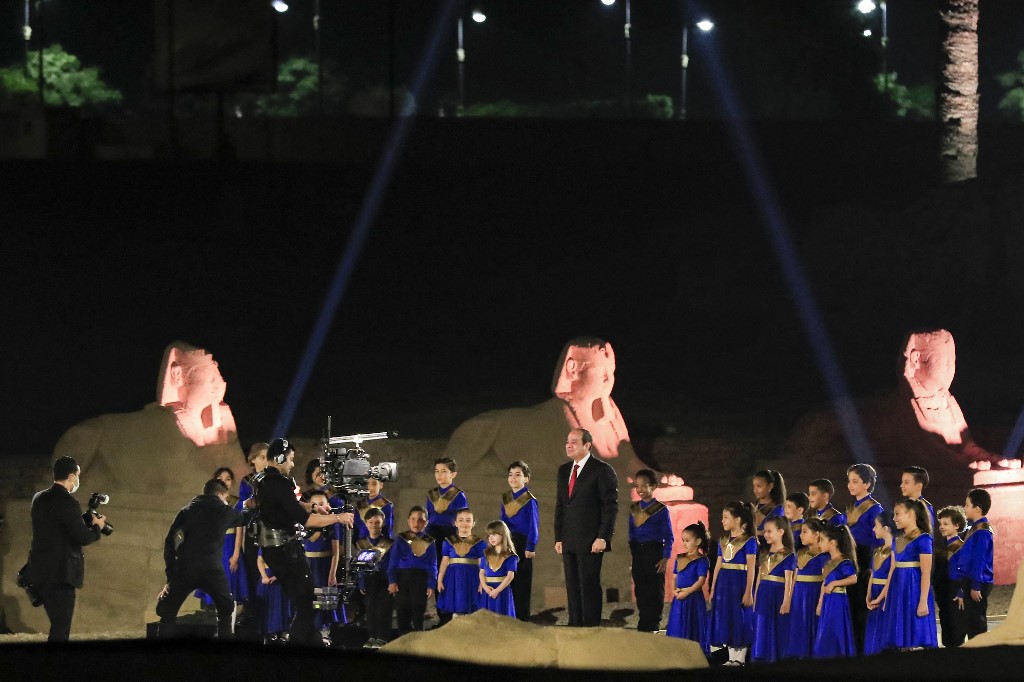 Le président égyptien Abdel Fattah al-Sisi pose pour une photo avec des enfants entre les sphinx à tête humaine dans une section le long de la "Route Rams", longue de 2700 mètres, menant du temple de Louxor (construit vers 1400 avant JC) au temple de Karnak plus au nord, dans la ville du sud de l'Égypte du même nom le 25 novembre 2021.