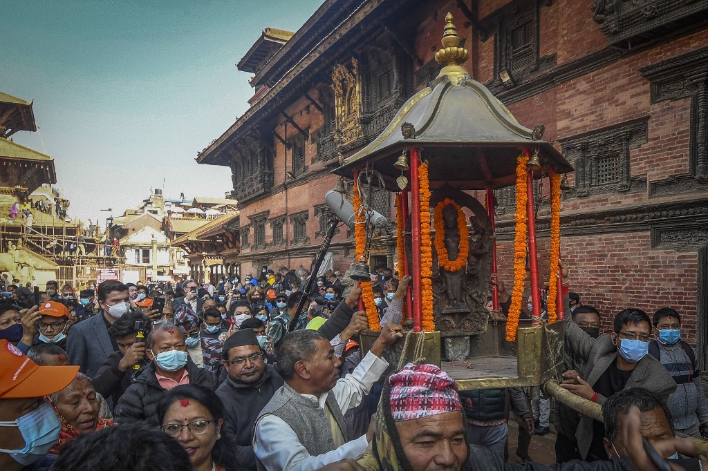 Les fidèles portent une sculpture centenaire d'un dieu hindou qui sera réinstallée dans son temple de Patan (Lalitpur) à la périphérie de Katmandou le 4 décembre 2021, près de 40 ans après son vol et son apparition plus tard aux États-Unis.