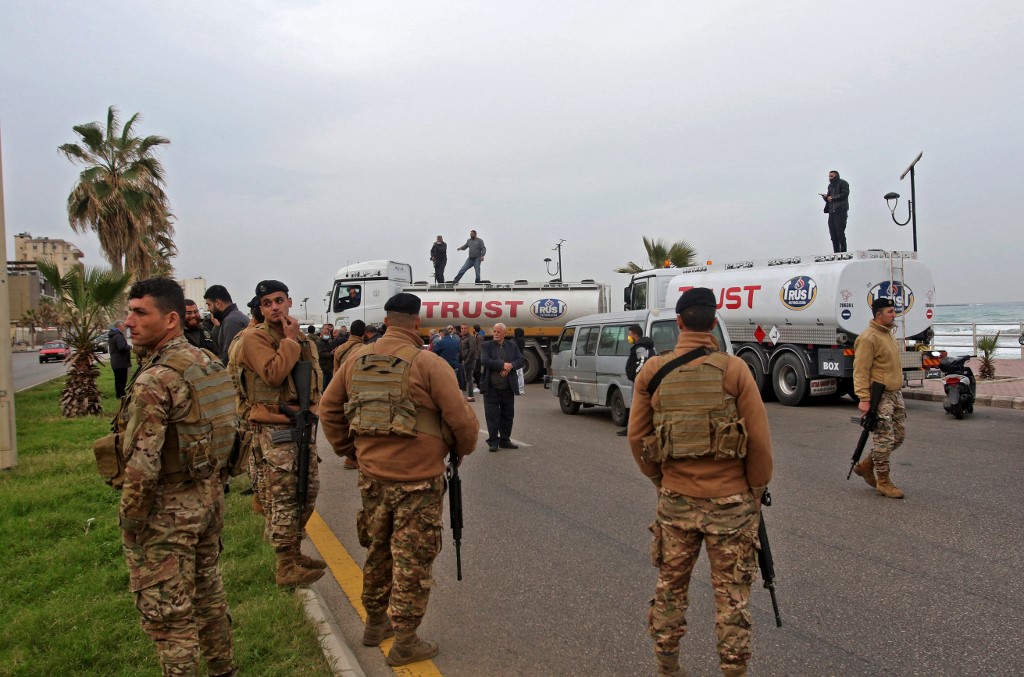 Les forces de sécurité libanaises montent la garde alors que des manifestants bloquent la principale route maritime de la ville de Saida, dans le sud du Liban, lors de la grève. (Photo, AFP)