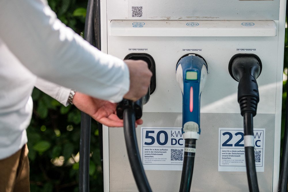 Un employé connecte un câble de voiture électrique à une station de chargement du fabricant allemand de voitures, Volkswagen. (AFP/File Photo)