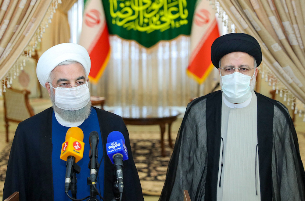 Le président sortant, Hassan Rohani (à gauche), participe à une conférence de presse aux côtés du nouveau président, Ebrahim Raïssi (à droite), dans le cadre de sa visite pour féliciter l’ultraconservateur d’avoir remporté l’élection présidentielle. (AFP/Présidence iranienne)