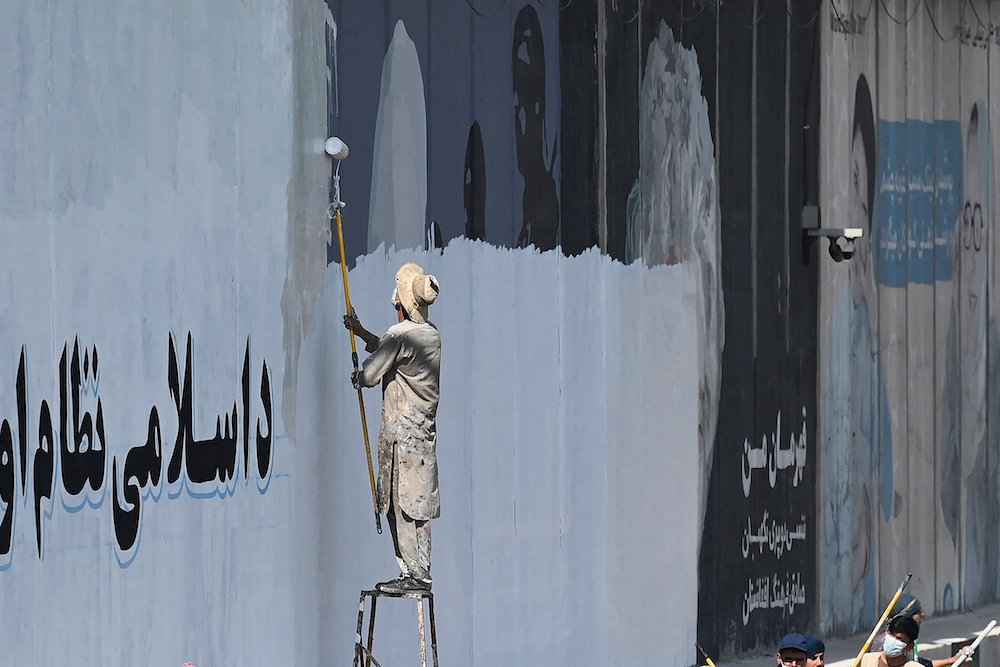 Un homme peint un mur de béton le long d'une rue de Kaboul, le 4 septembre 2021. (Photo, AFP)
