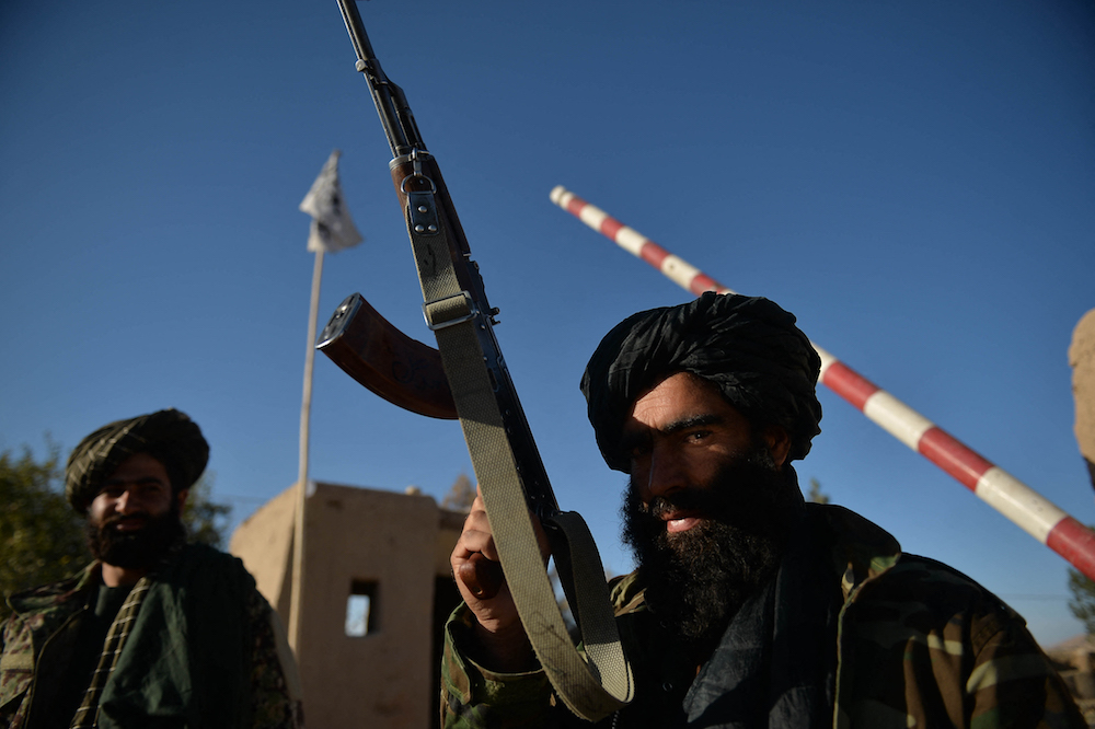 Des combattants talibans montent la garde devant un poste de police dans la zone de Ghasabha à Qala-e-Now, dans la province de Badghis, le 14 octobre 2021. (AFP/File Photo)