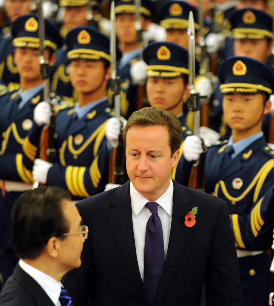 Le Premier ministre britannique, David Cameron, (au centre) marche aux côtés du Premier ministre chinois, Wen Jiabao (à gauche), avec un coquelicot à la boutonnière, pour rendre hommage aux soldats britanniques tués au combat, lors de la cérémonie d’accueil de la garde d’honneur au palais de l’assemblée du peuple à Pékin, le 9 novembre 2010. (AFP)