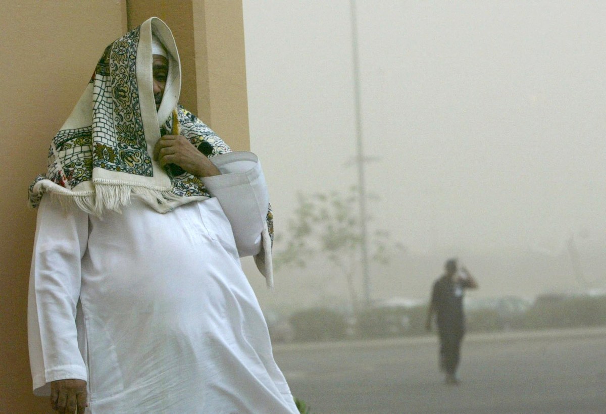 Un Saoudien se couvre le visage à l’aide d’un tapis de prière lors d’une tempête de sable, à Djeddah. (AFP)