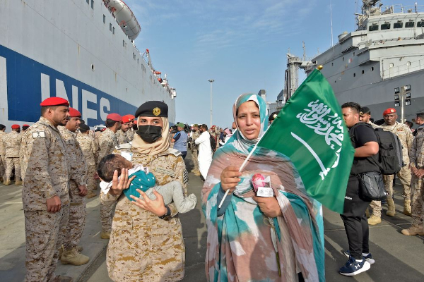 Des membres de la force navale saoudienne accueillent des évacués à la base navale du roi Faisal à Djeddah le 26 avril 2023 à la suite d'une opération de sauvetage depuis le Soudan (AFP).