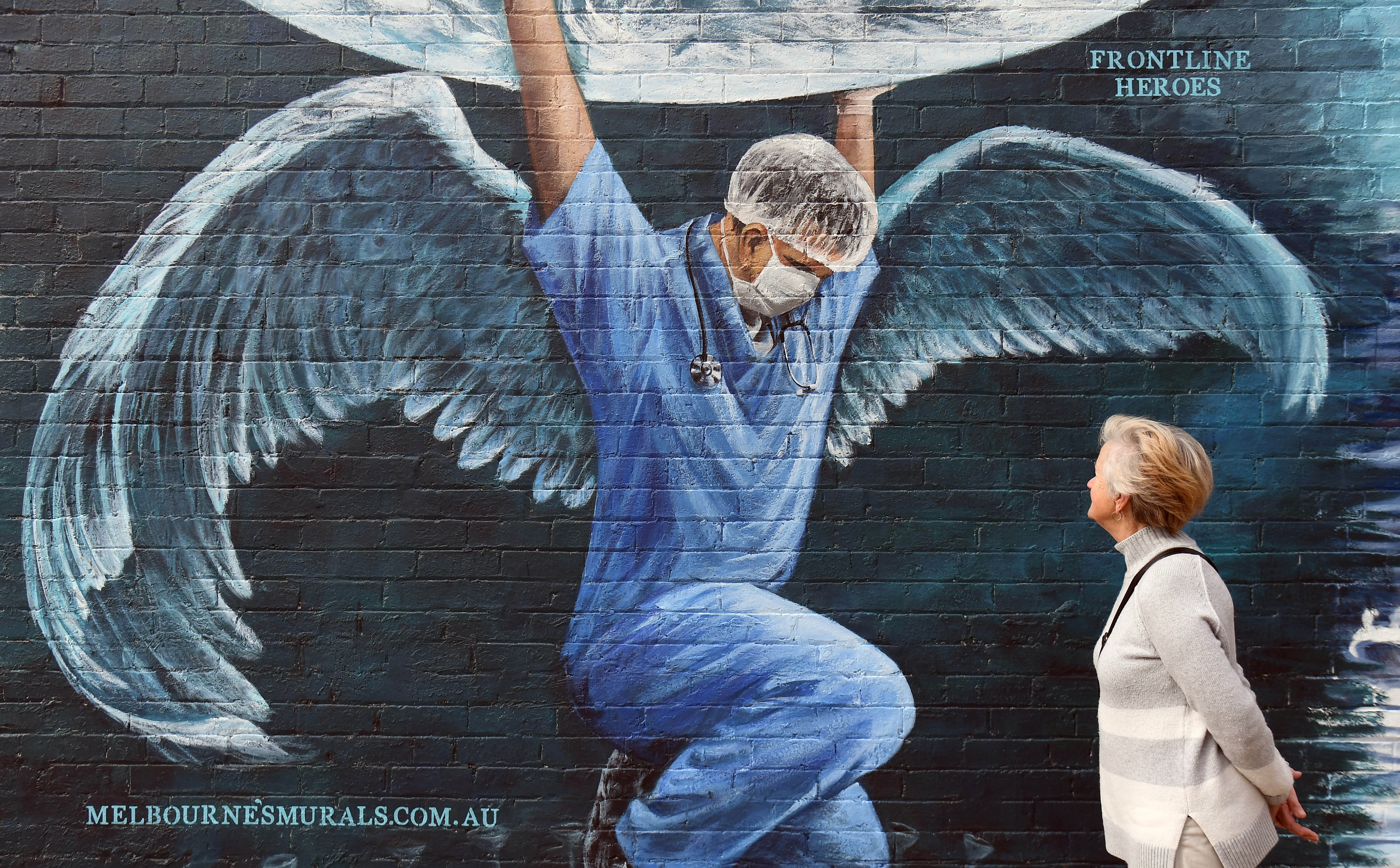 Passante devant une peinture murale pendant la Journée internationale des Infirmières (William West, AFP)