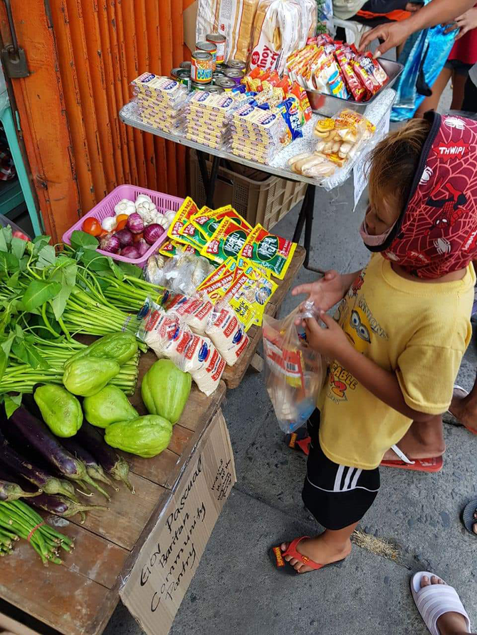 Un jeune homme choisit des produits alimentaires et d'autres articles essentiels dans le garde-manger communautaire du gouverneur Pascual à Malabon. (Photo de la page Facebook de Nine Louise Tesorero)