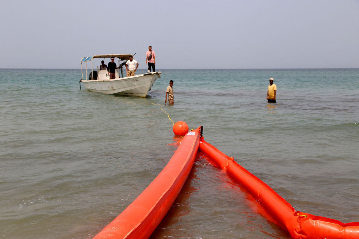 Des résidents yéménites déploient des barrages flottants pour protéger la côte d'une marée noire du FSO Safer dans le district d'Al-Khawkhah, dans la province occidentale de Hodeida, le 13 juillet 2023 (AFP).