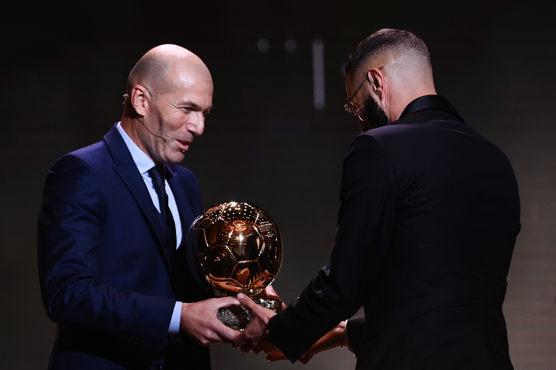 L'attaquant français du Real Madrid Karim Benzema (D) reçoit le Ballon d'Or des mains de l'ancien attaquant français Zinedine Zidane lors de la cérémonie de remise des prix Ballon d'Or France Football 2022 au Théâtre du Châtelet à Paris le 17 octobre 2022.