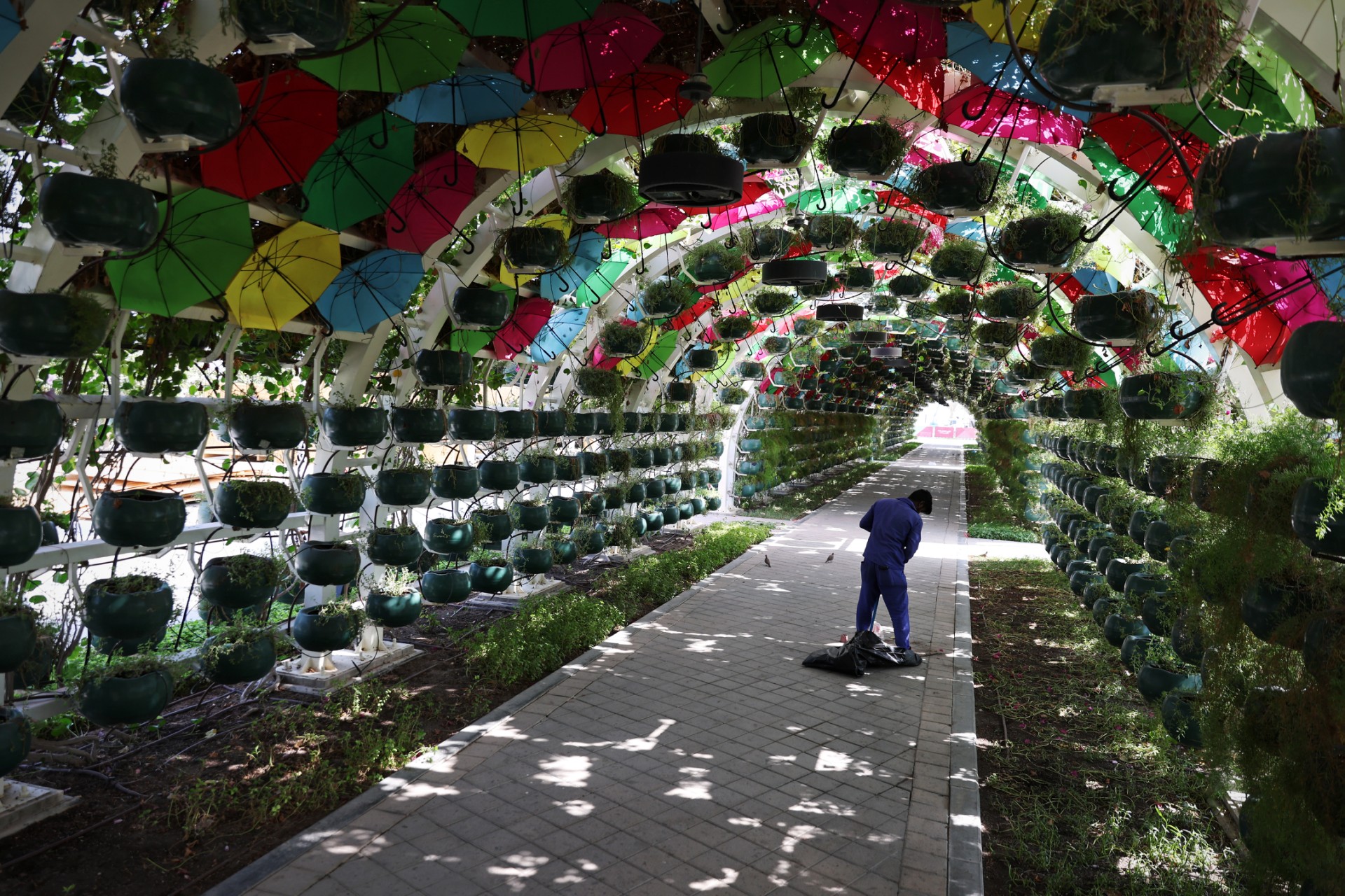 Un ouvrier balaie le trottoir à l'intérieur d'un tunnel dans la fan zone officielle de la Corniche, à Doha le 14 novembre 2022 (Photo, AFP).