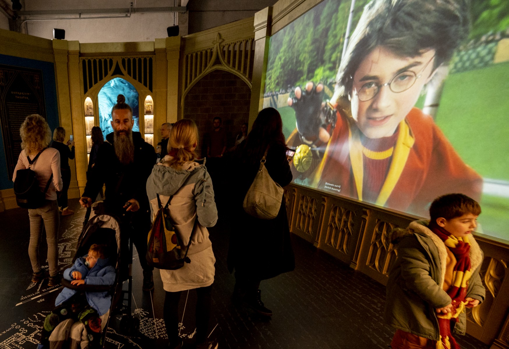 Des visiteurs passent devant un écran montrant un extrait d'un film lors de l'ouverture de l'exposition européenne de Harry Potter à Vienne, en Autriche, le 16 décembre 2022 (Photo, AFP).