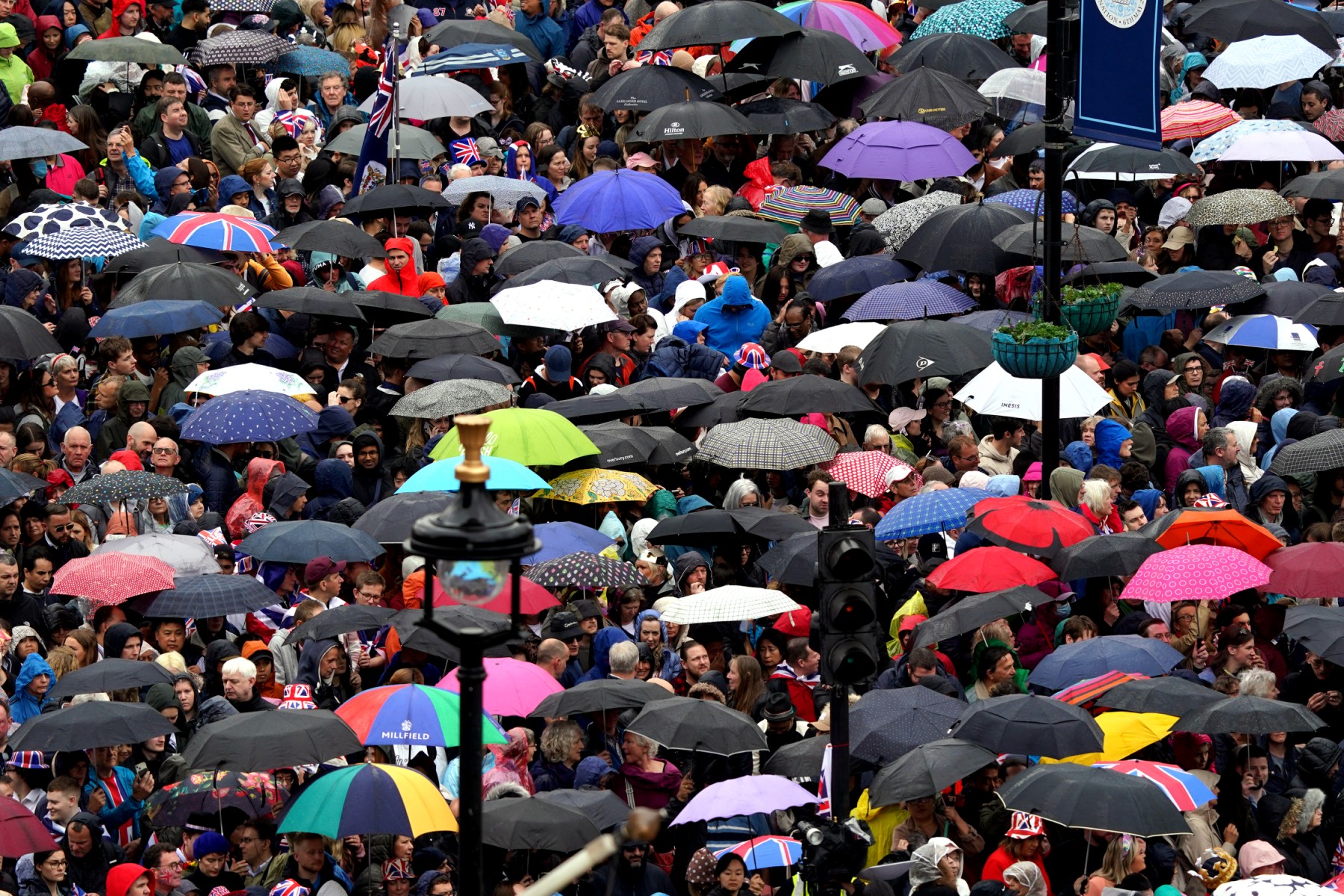 Des foules près de Trafalgar Square ouvrent leurs parapluies avant la cérémonie de couronnement du roi Charles III et de Camilla, reine consort de Grande-Bretagne dans le centre de Londres le 6 mai 2023 (Photo, AFP).