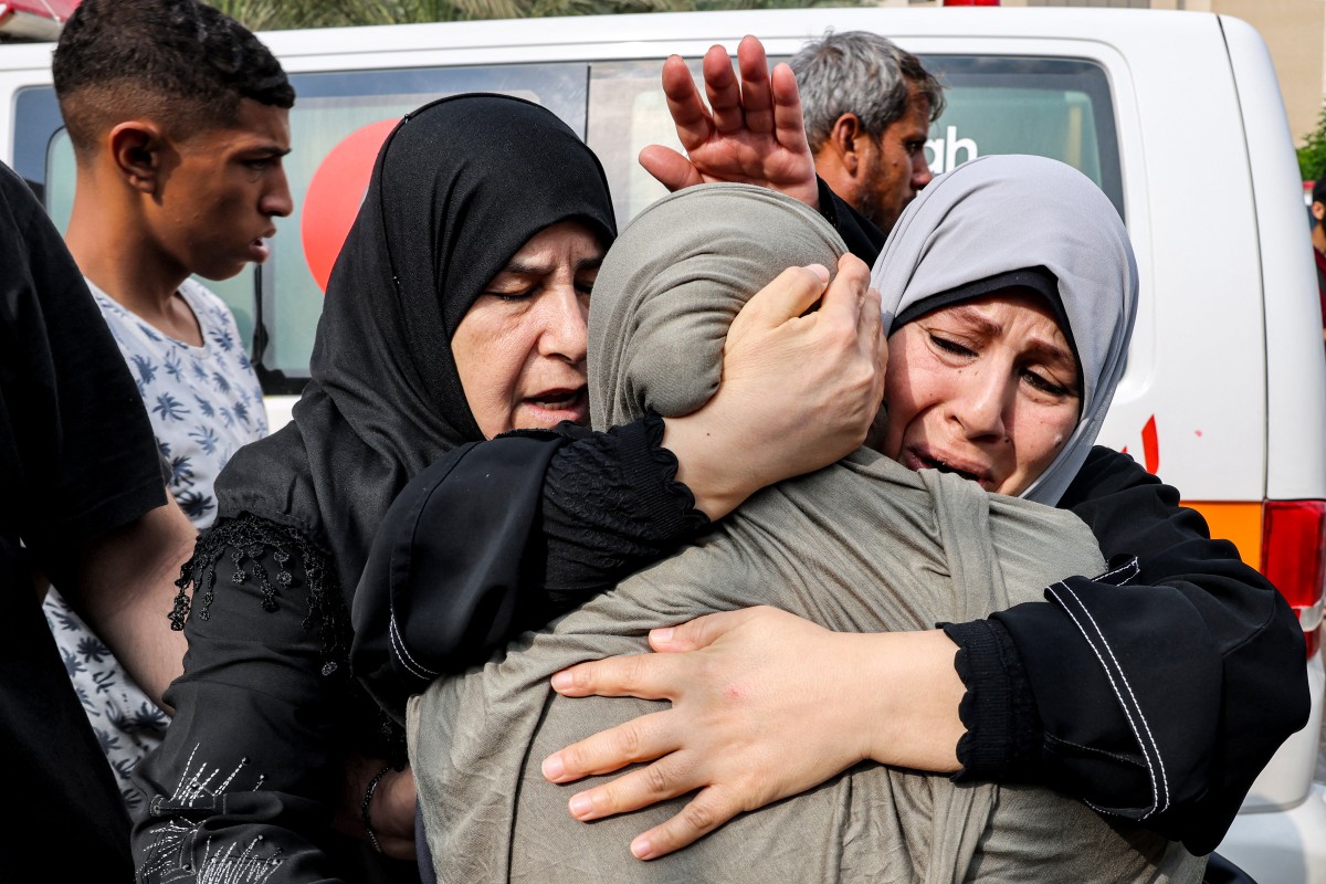 Des femmes consolent une autre femme en deuil pour ses proches tués lors d'une frappe aérienne israélienne à Khan Yunis, dans le sud de la bande de Gaza, le 11 octobre 2023 (Photo de SAID KHATIB / AFP).