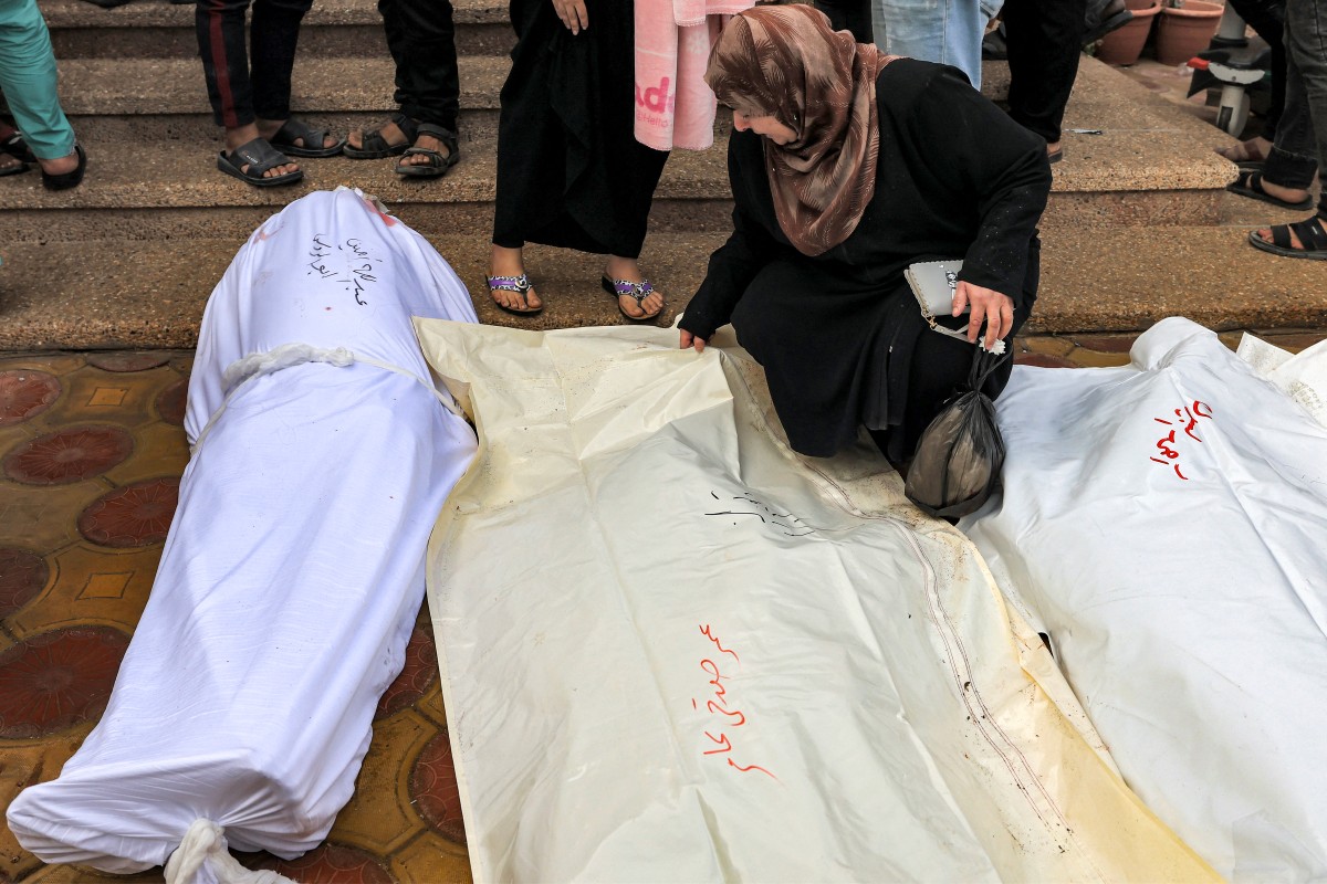 Une femme pleure devant le corps d'une victime palestinienne tuée lors des bombardements israéliens, avant ses funérailles devant la morgue de l'hôpital Nasser de Khan Yunes, dans le sud de la bande de Gaza, le 25 octobre 2023, au milieu des combats en cours entre Israël et le groupe palestinien Hamas (Photo de Mahmoud HAMS / AFP).