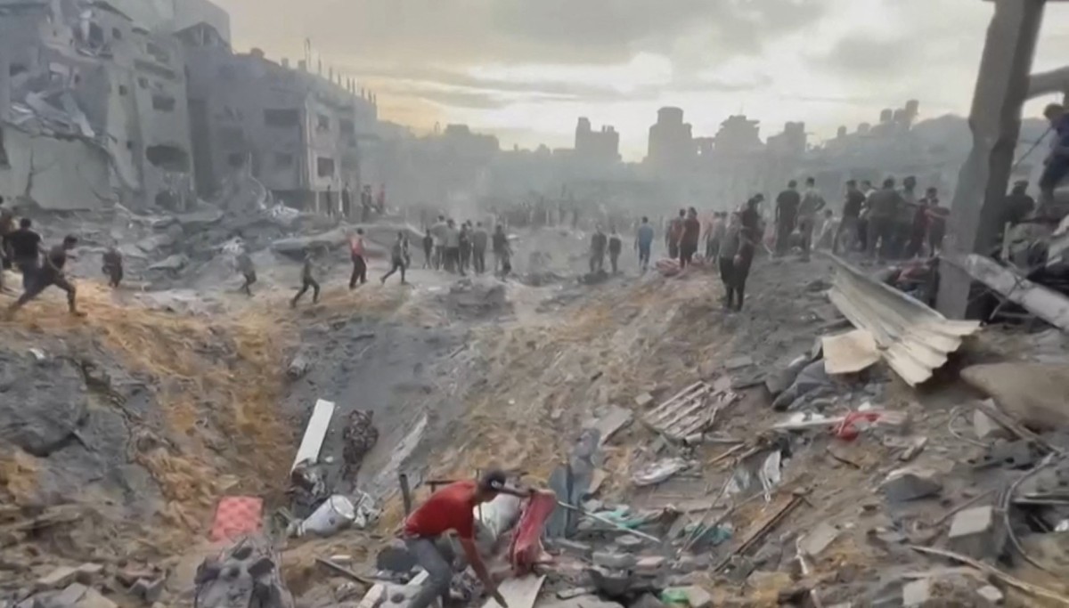 Cette image extraite d'une séquence vidéo de l'AFPTV montre des Palestiniens à la recherche de survivants dans un cratère à la suite d'une attaque contre un camp de réfugiés à Jabalia, dans le nord de la bande de Gaza, le 31 octobre 2023 (Photo de Fadi Alwhidi / AFP).