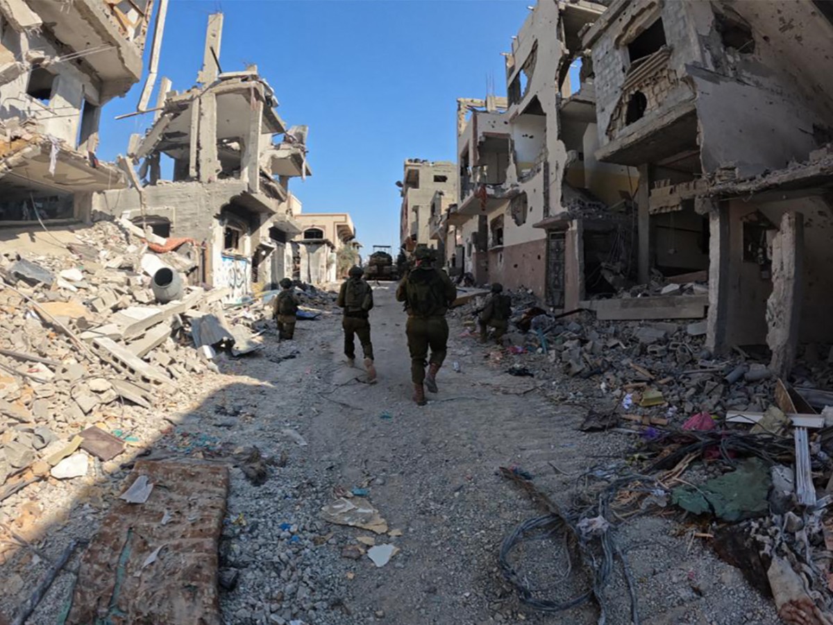 Des soldats marchent dans une zone de la bande de Gaza, au milieu des combats en cours entre Israël et le mouvement palestinien Hamas (Photo de l'armée israélienne / AFP).