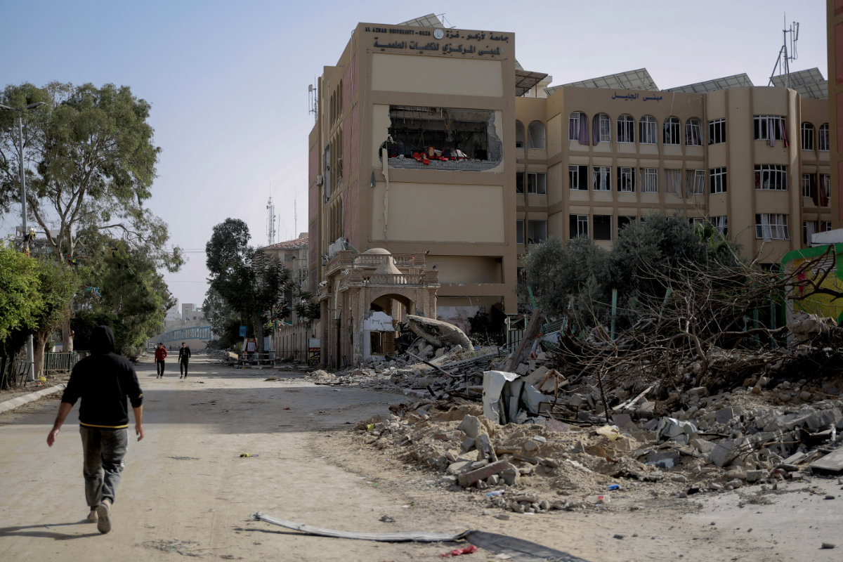 Des Palestiniens passent devant le bâtiment endommagé de l'une des facultés de l'université Al-Azhar à Gaza, le 26 novembre 2023, au troisième jour de la trêve entre Israël et le Hamas (Photo, AFP).