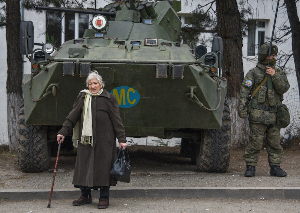 Margarita Khanaghyan, 81 ans, passe devant un véhicule blindé de la force russe de maintien de la paix dans la ville de Lachin, le 26 novembre 2020, après six semaines de combats entre l'Arménie et l'Azerbaïdjan au sujet de la région contestée du Haut-Karabakh (Photo, AFP).